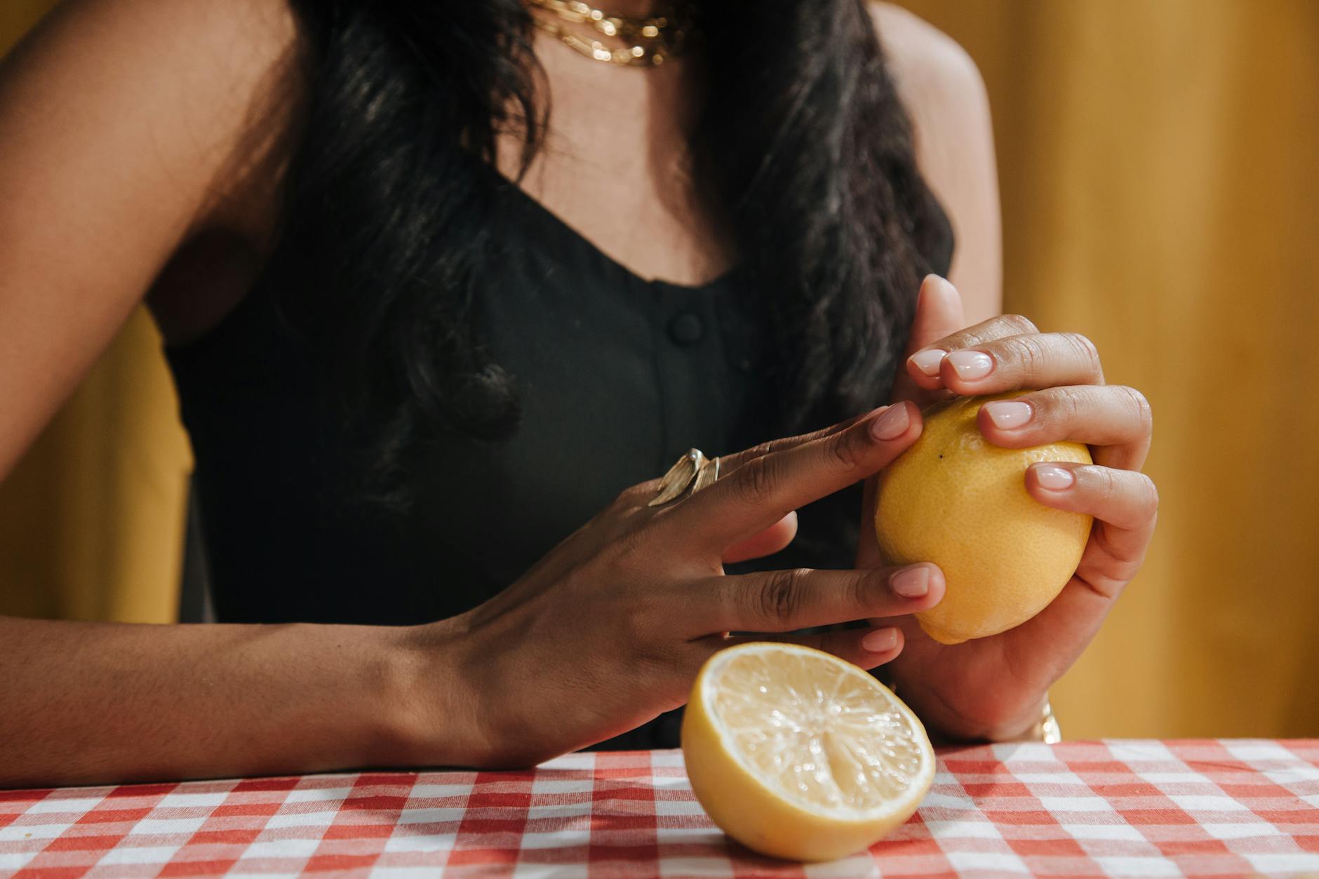Close-up of hands holding fresh lemons, symbolizing natural moisture and freshness