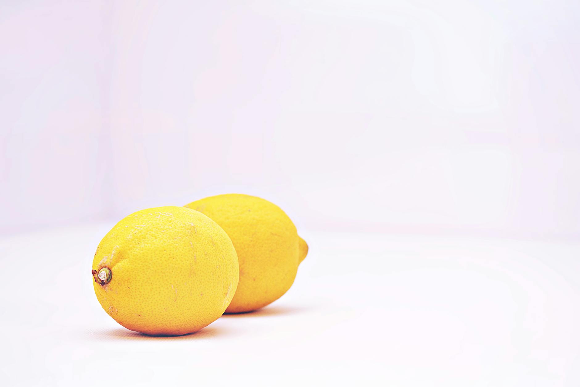 Two vibrant lemons on a minimalistic white background symbolizing freshness and sensitive nerve response