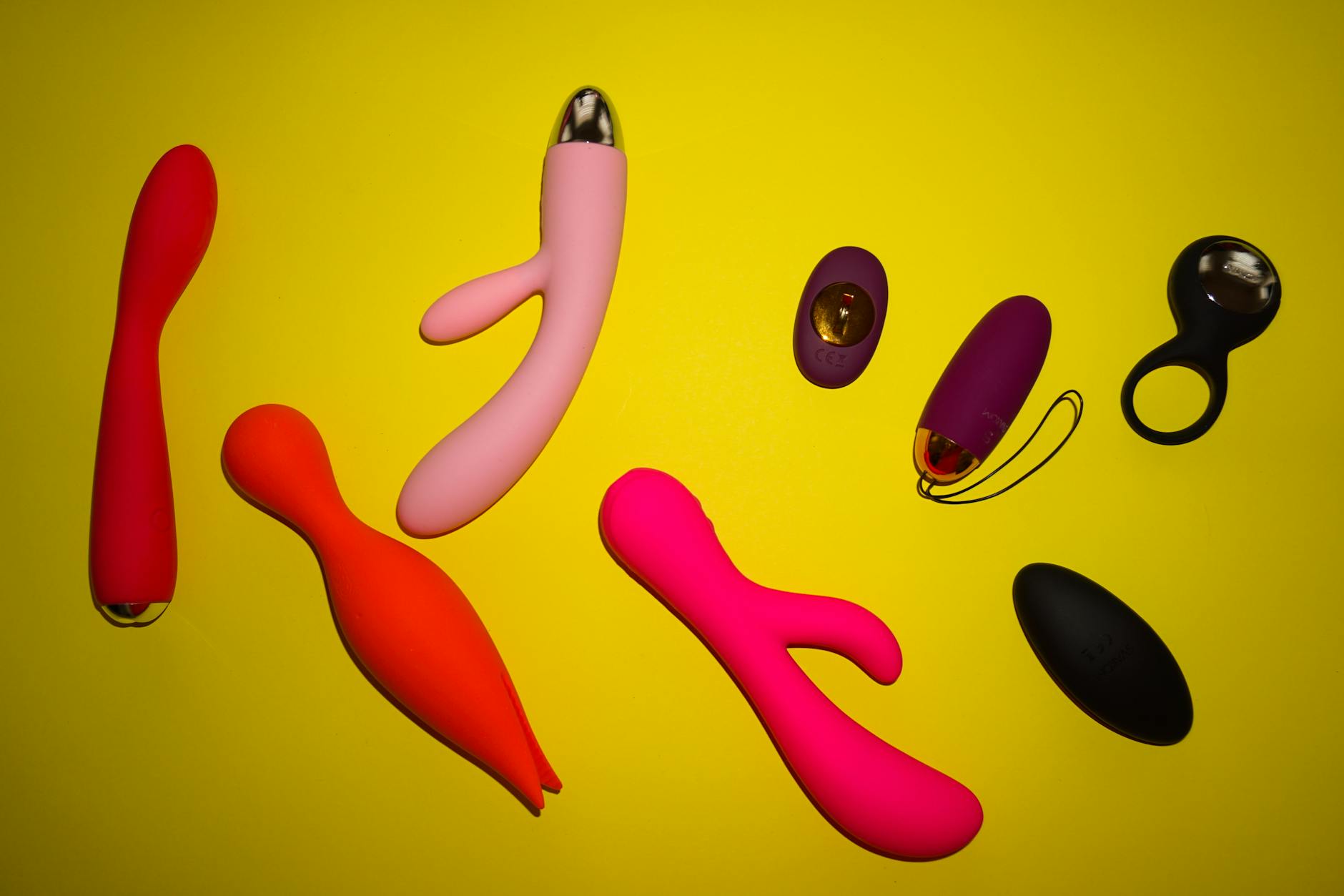 Vibrant collection of clitoral vibrators on a bright yellow surface