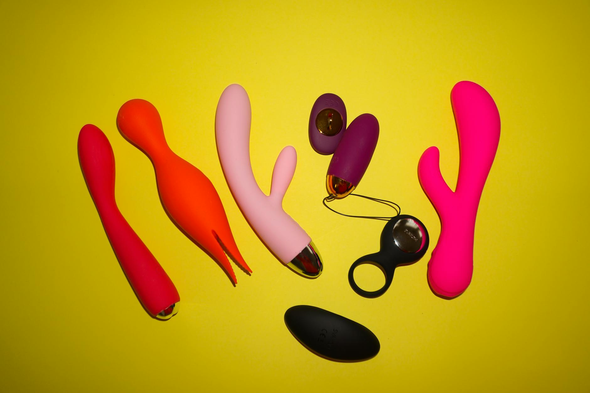 Close-up of hands holding a sleek blue vibrator against a purple background, representing discreet pleasure