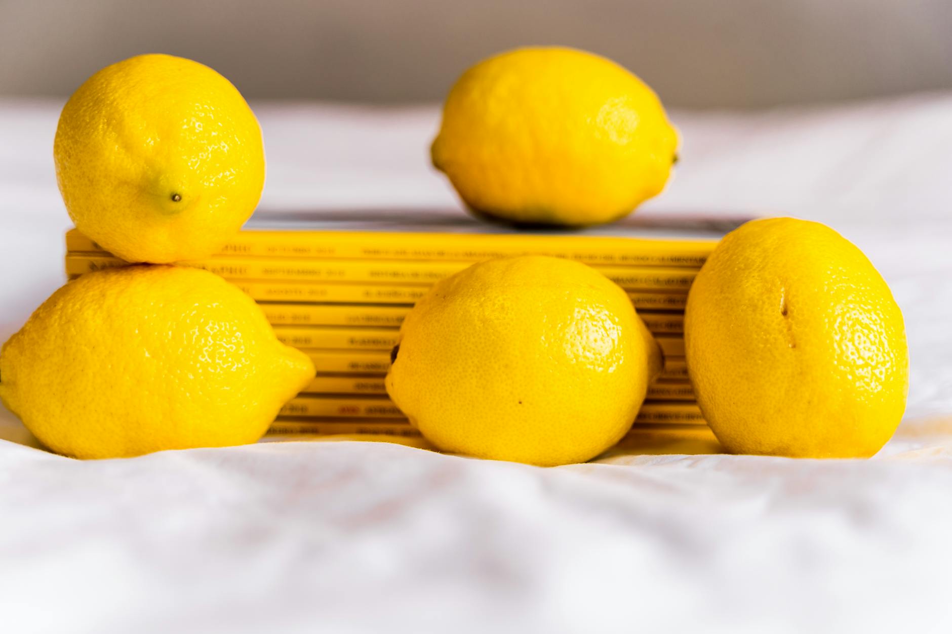 Hand holding a fresh lemon against a vivid yellow background, symbolizing hope and renewal